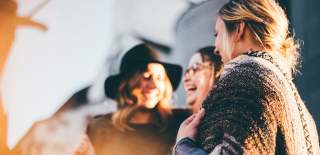 Photograph showing three women smiling as they enjoy a girls' holiday