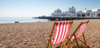 Red and white deckchairs on Southsea Beach, with South Parade Pier in the background