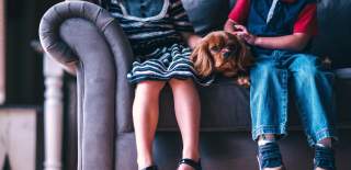Two people with a dog sat on a sofa at a dog-friendly place to stay in Portsmouth