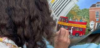 Louise Braithwaite painting a lion sculpture
