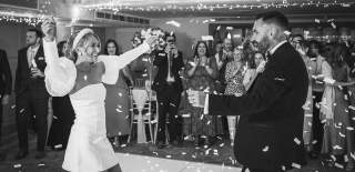 A bride and groom dancing amongst confetti, whilst friends and family watch, at Ellenborough Park