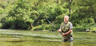 man fly fishing in a river