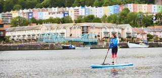 Person stand up paddleboarding in harbour