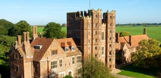 An impressive Tudor Tower, at least 8 stories high, nestles in verdant English countryside.