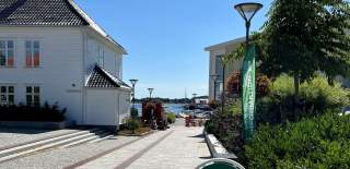 Informasjonsskilt i gate utenfor Visit Grimstad