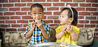 2 kids eating donuts