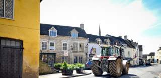A tractor driving through the centre of Tetbury