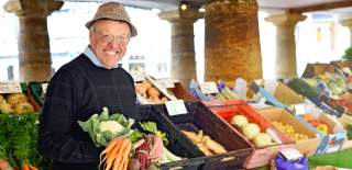 A smiling market trader under the Market House in Tetbury