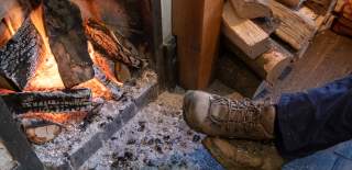 Walker warming their feet in front of a fire in Winchcombe