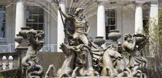 A large fountain depicting Neptune in a chariot drawn by four seahorses, accompanied by a merman blowing a conch shell