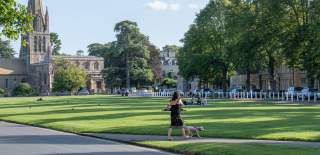 A woman walking her dog on Church Green in Witney