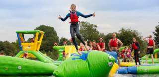 Children on inflatable assault course at Cotswold Country Park