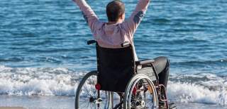 man in wheelchair on the beach