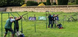 Two people are being taught clay pigeon shooting at Ian Coley Outdoor Pursuits