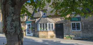Independent shops in honey-coloured stone buildings on Broadway High Street