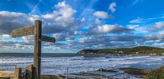 View of Croyde Bay with coastal path signs