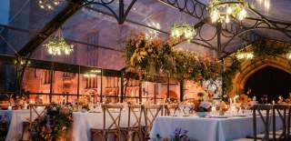 As dusk draws in the wedding breakfast is lit by chandeliers and candles at Sudeley Castle
