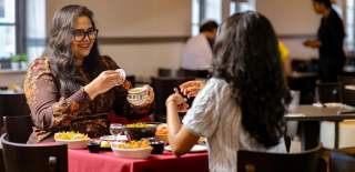 Two people sat opposite each other eating at Mint Dosa