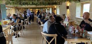Groups of people sit at tables 'speed dating' in a large room