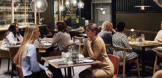 Mennesker som sitter i restauranten til Quality Hotel Sarpsborg. Foyo.