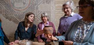 An expert tour guide talks to a group about artefacts at the Corinium Museum