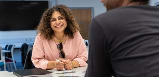 a close up of 2 people at a workshop talking and smiling