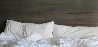 White bedding against a wood-panelled wall