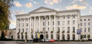 Queens Hotel Cheltenham, view of the exterior of the hotel in the summer with hanging baskets.
