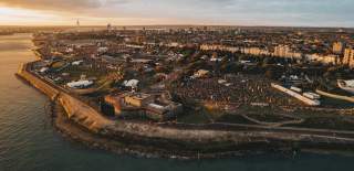 Aerial photograph showing the Victorious Festival site at the golden hour, with Southsea Castle in the foreground