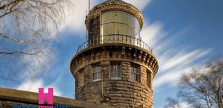 Bidston Lighthouse, a brick tower in a blue cloudy sky