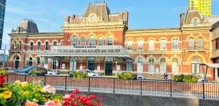 Photograph showing the front elevation of Portsmouth and Southsea Railway station with the sun shining on much of it.