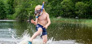 Boy with a diver mask swimming in lake