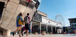 Couple walking in Millennium Square on Bristol's Harbourside - credit Visit West