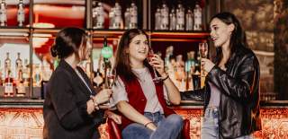 Three women enjoying a drink at Margot.