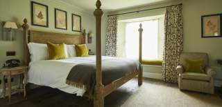 A bedroom with posts at The Pig Near Bath
