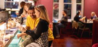 Couple sat at bar in restaurant