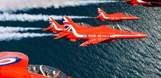 5 Red Arrows flying above open water
