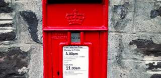 red Royal Mail postbox in wall