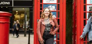 Ladies in Cheltenham, posing by phone boxes on Promenade