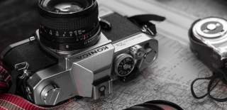 Photograph of a Konica camera and peripherals, on top of a map