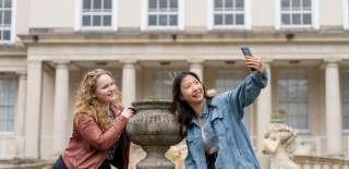 Visitors enjoying Cheltenham, taking a selfie near Neptune Fountain