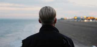 Photograph showing the back of a man on South Parade Pier looking out over Southsea Beach