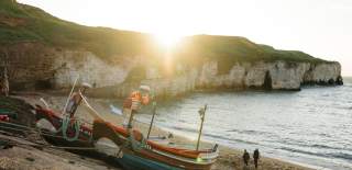The run rising over North Landing beach, cliffs and a coble.