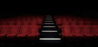 Photograph showing red cinema chairs in a row with an aisle down the middle