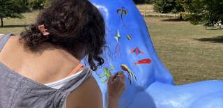 Louise Braithwaite painting kites on a lion statue