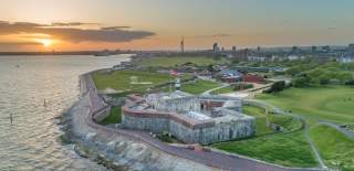 Photograph looking out over Southsea Castle, with Spinnaker Tower and the Portsmouth cityscape in the background