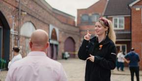 Guide on Coronation Street Tour set with visitors