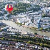 An aerial view of hot air balloons flying over Bristol Harbourside