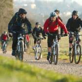 A group cycling on rented mountain bikes towards the off-road mountain biking trail at Ashton Court - credit Pedal Progression