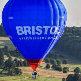 A blue balloon ascending from Ashton Court during the Bristol Balloon Fiesta with the Clifton Suspension Bridge in the background - credit Paul Gillis